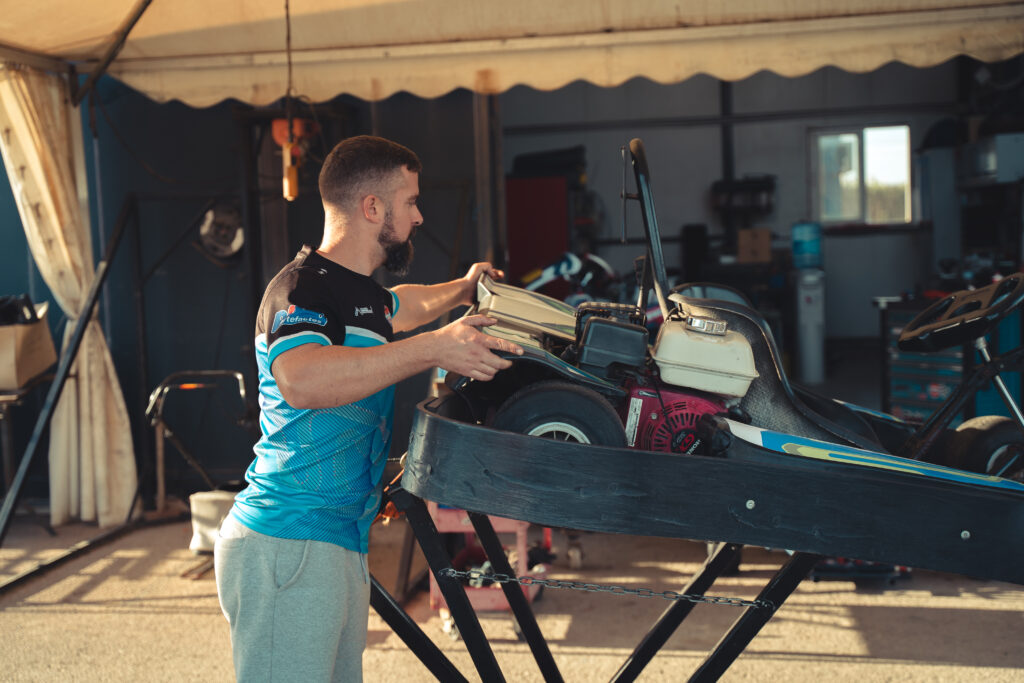 Mecánico realizando ajustes en un kart en el circuito de Torrevieja, preparando el vehículo para una jornada de competición.